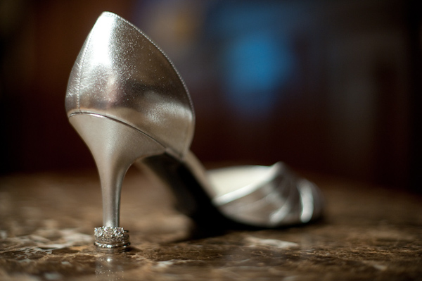 Wedding ring display - Silver wedding shoe with heel standing in middle of wedding rings -  photo by Houston based wedding photographer Adam Nyholt